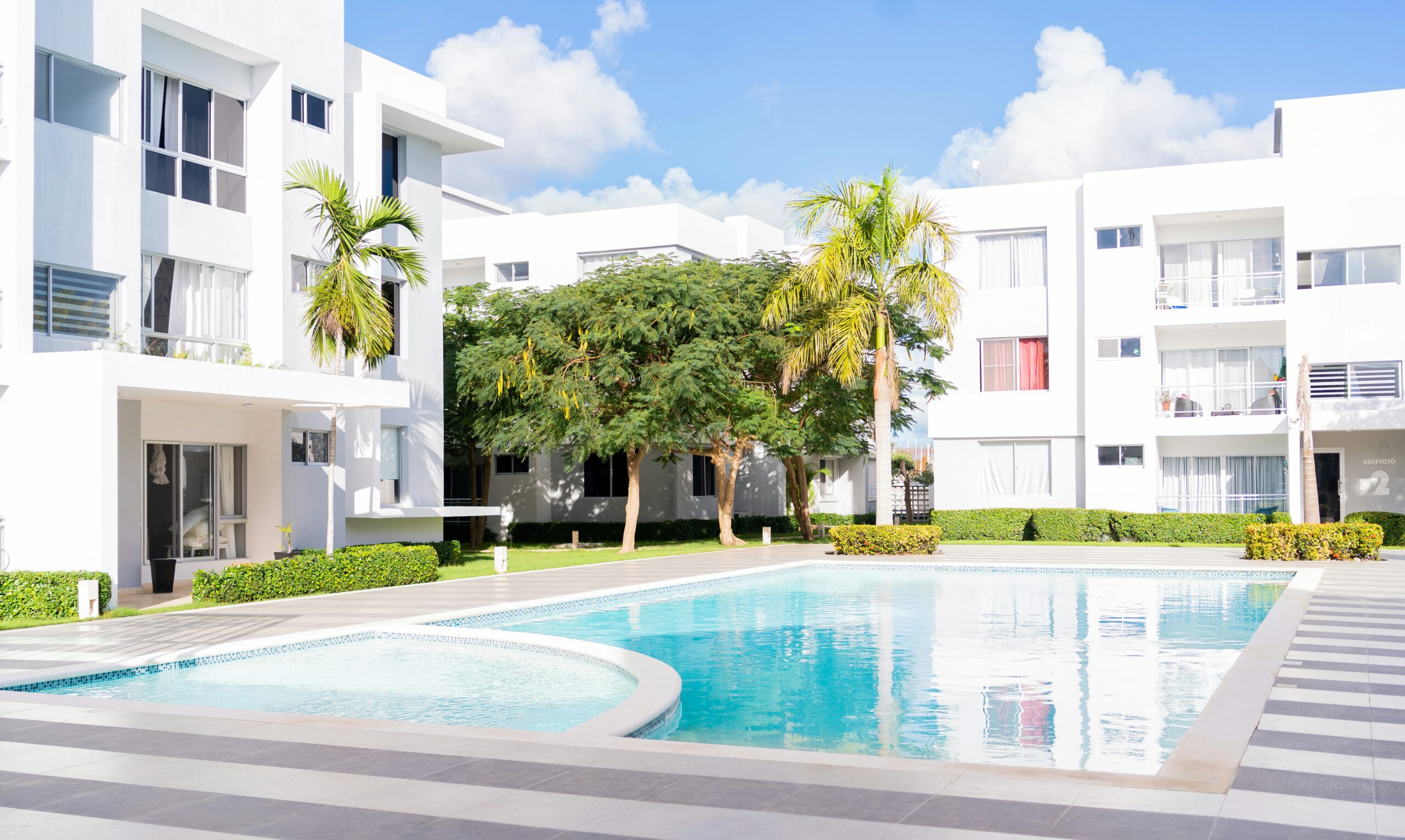 A swimming pool in front of a white building