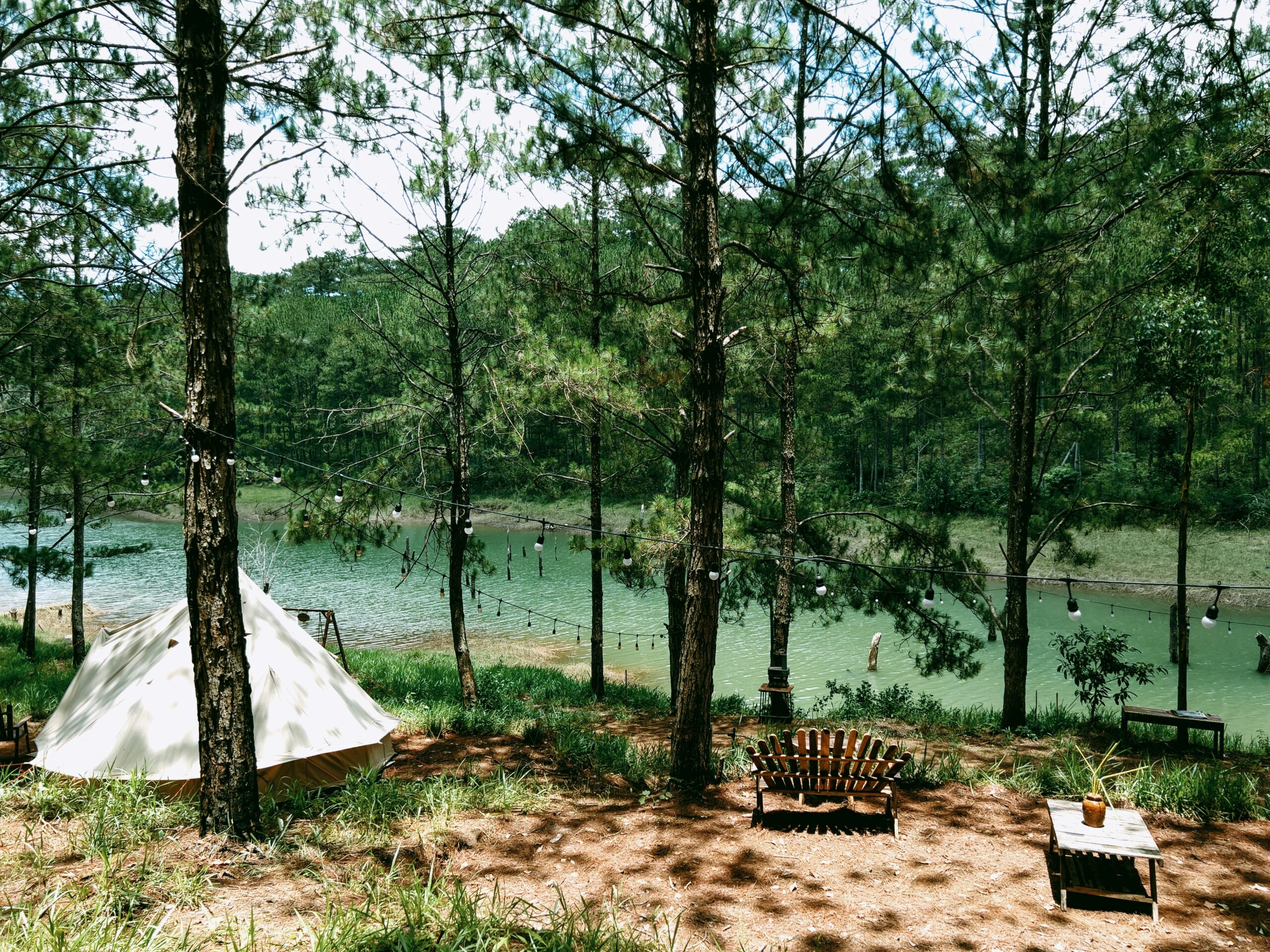 a tent in the woods next to a lake