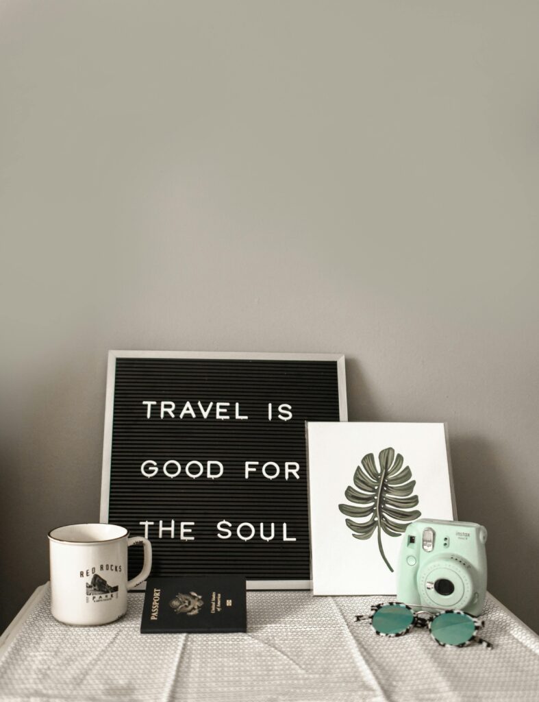 A travel-themed flat lay with a camera, coffee, and motivational quote.