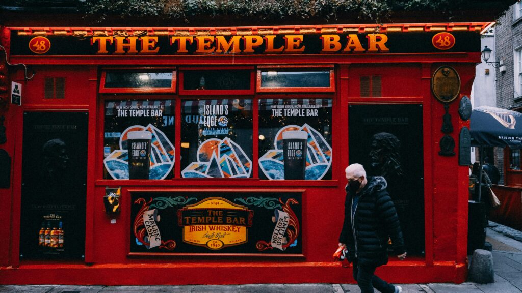 Iconic Temple Bar in Dublin, featuring its vibrant red facade on a bustling city street.