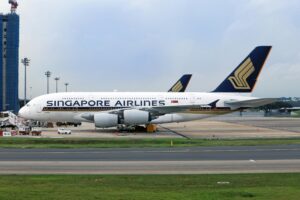 A Singapore Airlines Airbus A380 stationed at an airport terminal, ready for boarding.