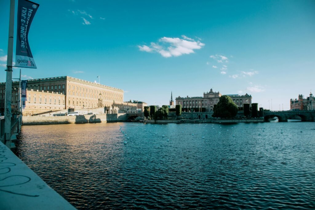 Panoramic view of the Stockholm Royal Palace by the waterfront in daylight.