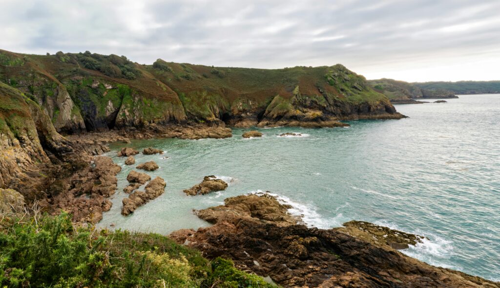 Breathtaking view of Jersey's rugged coastline with rocky cliffs and serene sea.