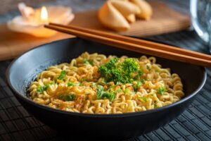 Aromatic bowl of instant noodles garnished with parsley and served with chopsticks.