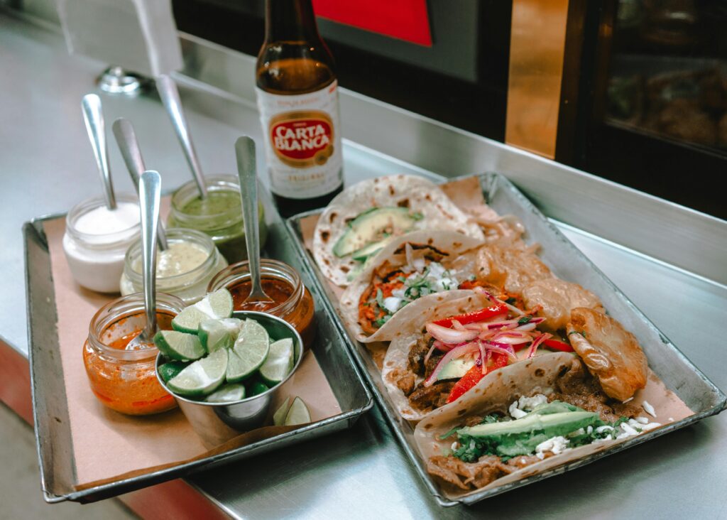 Delicious Mexican tacos served with sauces and lime, paired with Carta Blanca beer in Mexico City.