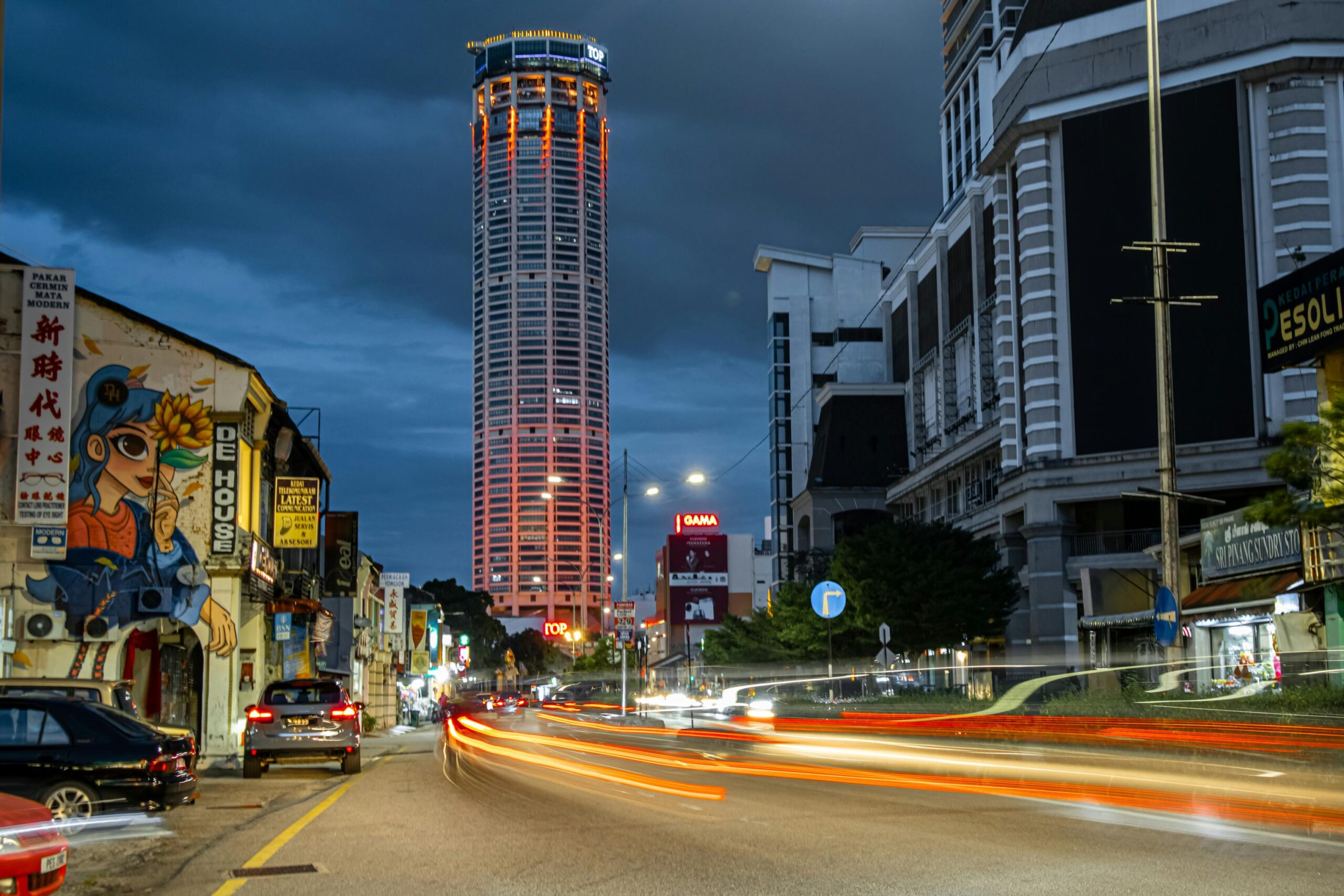 Dynamic night street scene in George Town, Penang, featuring the iconic KOMTAR Tower.