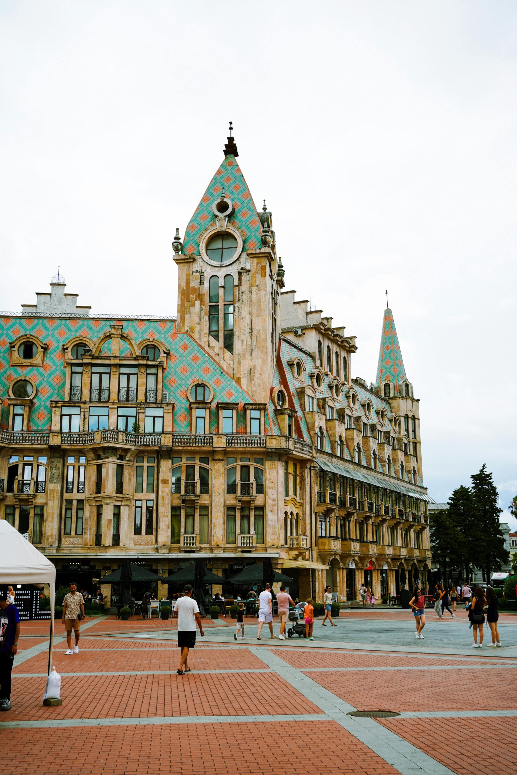 A stunning architectural building in Batumi's Europe Square with people enjoying the town square.