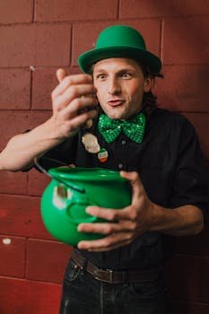 A joyful man with a green hat and bow tie holding a pot of gold on St. Patrick's Day.